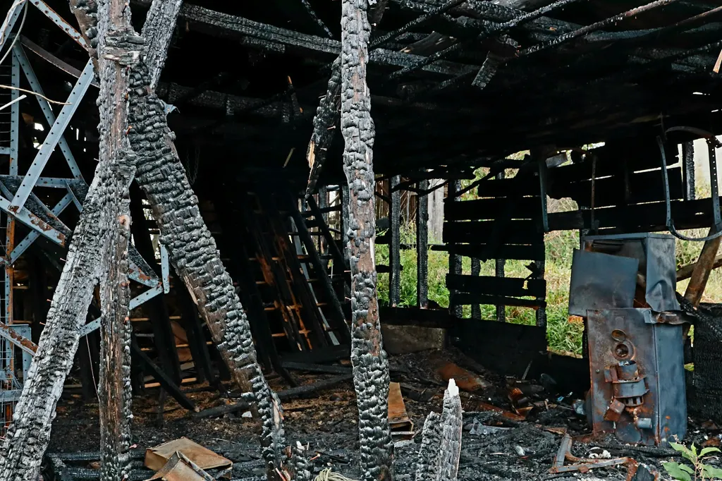 Burned interior structure with charred timber and debris after a fire